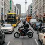 Motorcyclist stopped in traffic between cars and red buses on a busy London street